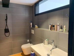 une salle de bain avec un lavabo, des toilettes et un miroir dans l'établissement Alps Rongchen Resort Apartment, à Chongli 20 autres photos