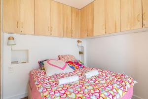 um quarto com uma cama colorida e armários de madeira em GuestReady - Charm Central in the 14th em Paris