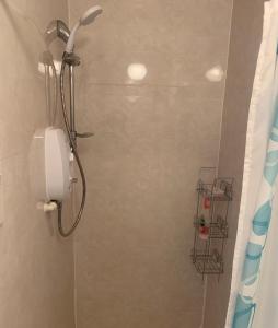 a shower with a phone in a bathroom at The Clan Boyd Room in Kilmarnock