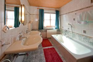 bagno con 2 lavandini e vasca di Hauser's Ferienhof a Hart im Zillertal
