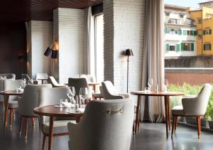a restaurant with tables and chairs and a window at Portrait Firenze - Lungarno Collection in Florence