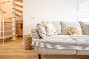 a living room with a gray couch with a pillow at GuestReady - Beachfront dream in Sesimbra in Sesimbra