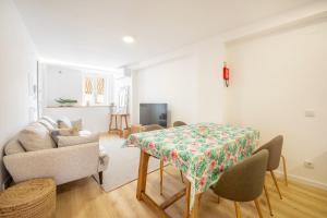 a living room with a table and a couch at GuestReady - Beachfront dream in Sesimbra in Sesimbra
