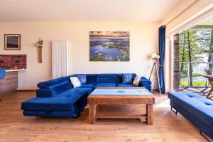 a living room with a blue couch and a table at Nautica Resort in Giżycko