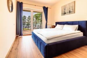 um quarto com uma cama e uma grande janela em Nautica Resort em Giżycko