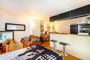 ein Wohnzimmer mit einem Sofa und einer Küche in der Unterkunft GuestReady - Magic View Montparnasse Big Terrace in Paris