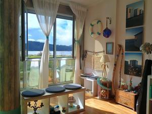 a living room with a large window and a table at El Camarote de Beiramar in Cedeira