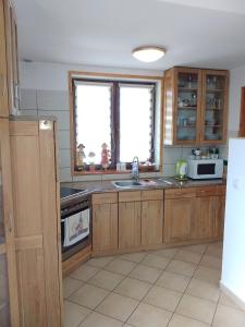 - une cuisine avec des placards en bois et un évier dans l'établissement Apartament u Micka Poronin 5 km od Zakopanego, à Poronin