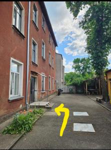 a yellow question mark on a street next to a building at Tiramisu in Ventspils