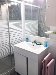 a white bathroom with a sink and a mirror at Amplio piso a 10 min de Salamanca by beBalmy in Santa Marta de Tormes