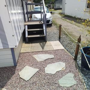 a yard with a stairway next to a house at Mobil-home dans camping calme in Pénestin