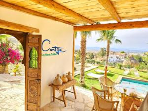 莫哈卡爾的住宿－B&B La Nava Suites，一个带桌椅的庭院和一个游泳池