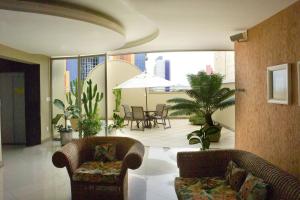 a living room with two couches and a table and chairs at Benvenuto Palace Hotel in Governador Valadares