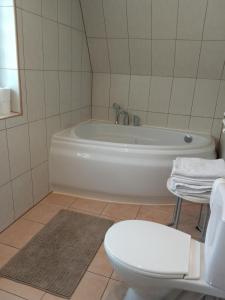 La salle de bains est pourvue d'une baignoire blanche et de toilettes. dans l'établissement Apartament u Micka Poronin 5 km od Zakopanego, à Poronin