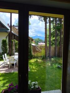 - une vue depuis la fenêtre d'une cour avec une table et des chaises dans l'établissement Apartament u Micka Poronin 5 km od Zakopanego, à Poronin