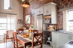 a kitchen with a table and chairs and a brick wall at Luname`s in St Helena Bay +14 photos