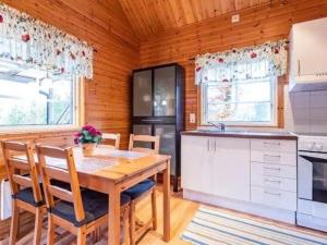una cocina con mesa y sillas en una cabaña en Ferienhaus Abborren in Seenähe inklusive kostenfreiem wlan und eigenem Ruderboot, en Hallaryd