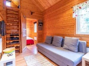 una sala de estar con sofá en una cabaña de madera en Ferienhaus Abborren in Seenähe inklusive kostenfreiem wlan und eigenem Ruderboot, en Hallaryd