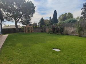 un gran patio con una valla y un árbol en Casa de sol, piscina y jacuzzi con 4 hab en Comunidad de Madrid en Algete