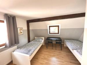 Zimmer mit 2 Betten und einem Tisch in der Unterkunft Monteurunterkunft Schwarzenbruck in Schwarzenbruck