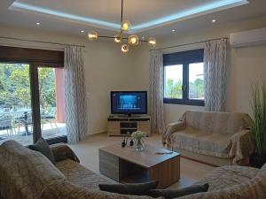 sala de estar con sofá y TV en Villa Sunset, en Samos