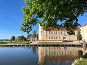 a building with a lake in front of it at Ferienwohnungen an der Stadtvilla Rheinsberg in Rheinsberg
