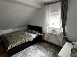 a small bedroom with a bed and a window at FlattyOne Ruhrgebiet - Schlafkomfort und Anbindung - neu renoviert in Bochum