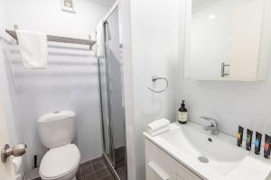 Baño blanco con aseo y lavamanos en Snowcreek 2 Alpine Chalet, Private Garage en Thredbo