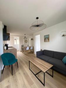 a living room with a couch and a table at Les Apparts de St Mart in Bréhal