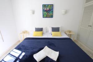 een slaapkamer met een groot blauw bed met gele kussens bij TESS Villa Ellen Maria: Space, Activity, Freedom! in Alhaurín de la Torre