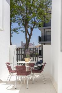 a table and chairs on a balcony with a tree at Apartamento Playa de Regla con terraza 1 in Chipiona