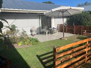 a patio with an umbrella and a table and chairs at Milkwood Haven in Pennington
