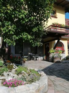 a patio of a house with a table and chairs at Apartment Tela in Kobarid