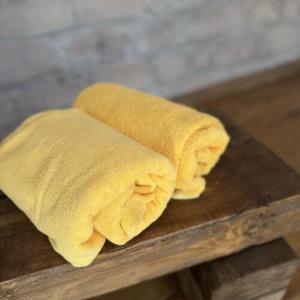 un asciugamano giallo seduto sopra un tavolo di legno di Pelini - 1 a Szentendre