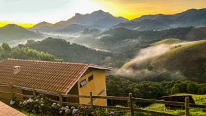 a house with a view of a valley with mountains at Pousada Portal do Céu in Visconde De Maua
