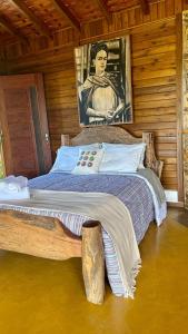 a bedroom with a large bed with a painting on the wall at Pousada Portal do Céu in Visconde De Maua +31 photos