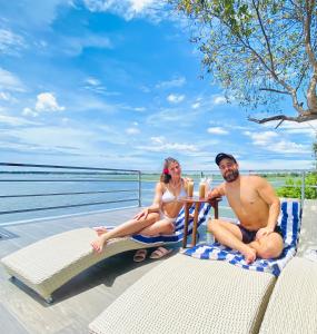 a man and woman sitting at a table on the beach at Oruwa Boutique Villas in Arugam Bay