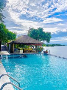 a swimming pool with a gazebo next to the water at Oruwa Boutique Villas in Arugam Bay