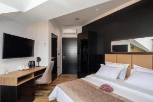 a bedroom with a bed and a desk and a television at Top rooms in Split