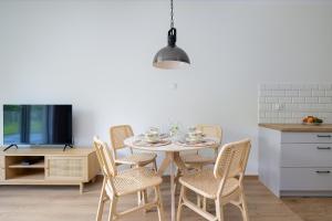 cocina con mesa con sillas y TV en Apartament z Tarasem by Noclegi Renters, en Szczecin