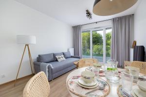 Una sala de estar con una mesa y sillas y un sofá. en Apartament z Tarasem by Noclegi Renters, en Szczecin