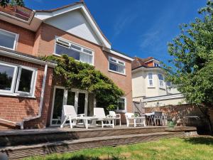 a patio with white chairs and a table on a house at Great stay in a beautiful and cosy house in Bournemouth