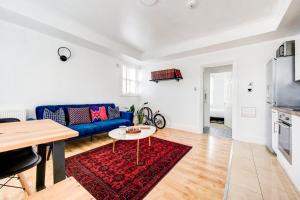 ein Wohnzimmer mit einem blauen Sofa und einem Tisch in der Unterkunft GuestReady - Estadia de charme em Limehouse in London