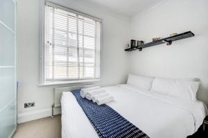 a bedroom with a white bed with two towels on it at GuestReady - Estadia de charme em Limehouse in London