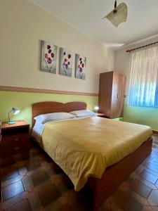 a bedroom with a large bed and paintings on the wall at Albergo Mendolia in Milazzo