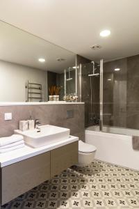 a bathroom with a sink and a toilet and a shower at Elija Penthouse in Palanga