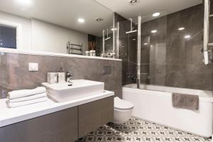 a bathroom with a sink and a toilet and a shower at Elija Penthouse in Palanga +12 photos