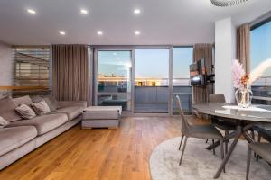 a living room with a couch and a table at Elija Penthouse with Sea View & Terrace - Near Beach - Free Parking in Palanga