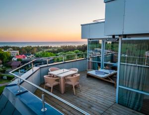 a balcony with a table and chairs on a building at Elija Penthouse in Palanga