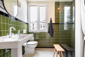 ein grün gefliestes Bad mit einem Waschbecken und einem WC in der Unterkunft GuestReady - Estadia na moda em Saint-Mandé in Saint-Mandé